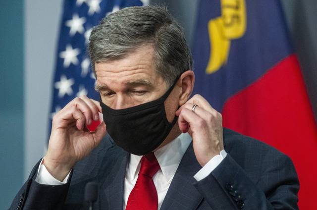 Travis Long | The News & Observer via AP Gov. Roy Cooper removes his mask before answering a reporter’s question during a briefing on North Carolina’s coronavirus pandemic response at the NC Emergency Operations Center, Wednesday, Sept. 30, 2020, in Raleigh, N.C.