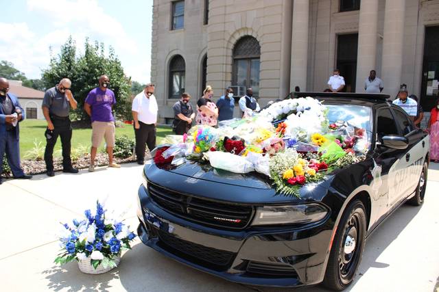 
			
				                                Gavin Stone | Daily Journal
                                Well wishers placed flowers on the hood of a Sheriff’s Office cruiser parked in front of the Courthouse in honor of the passing of Sheriff James Clemmons.
 
			
		