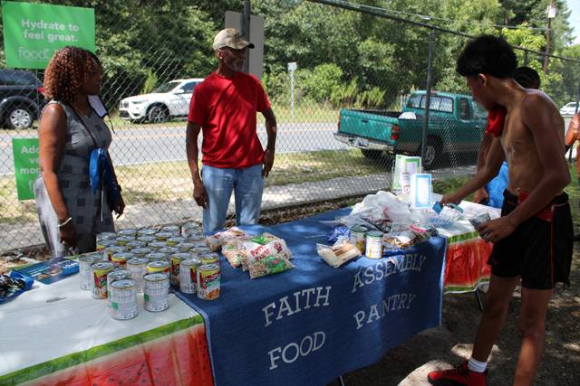 <p>Linda and Mordecai Ross, at left, run the table for the Faith Assembly Food Pantry on Saturday.</p> <p>Gavin Stone | Daily Journal</p>
