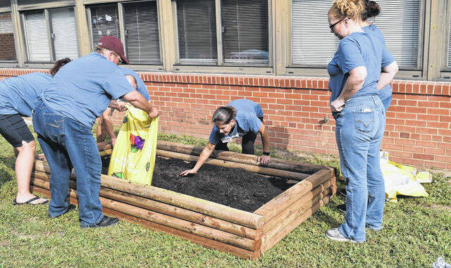  Volunteers building a garden bed for the Exceptional Students Department at Monroe Avenue Elementary School in 2019. Contributed photo 