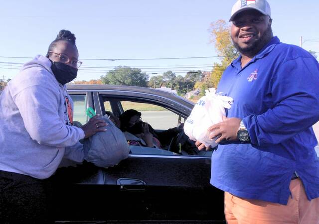 
			
				                                Chellia Nelson and her brother James Everette at the turkey and ham giveaway Saturday morning.
 
			
		
