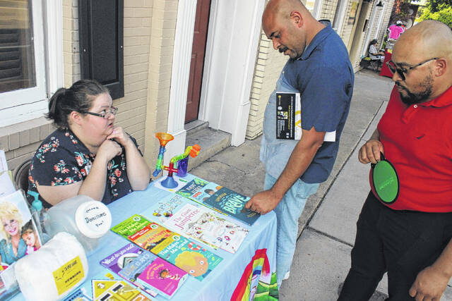 <p>Jonathon Lewis and DaTwon Canty peruse some available books courtesy of Elizabeth Rizzo with the Richmond County Partnership for Children.</p>